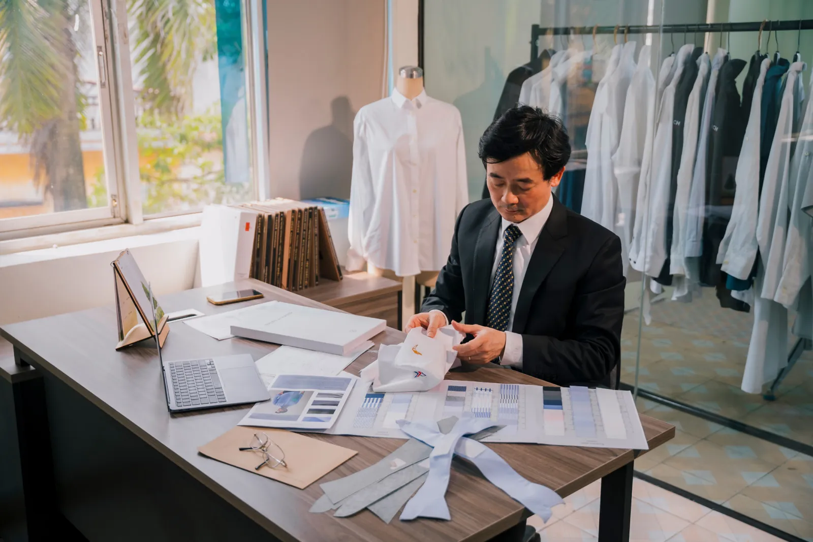 A tailor checking the collar of a new shirt