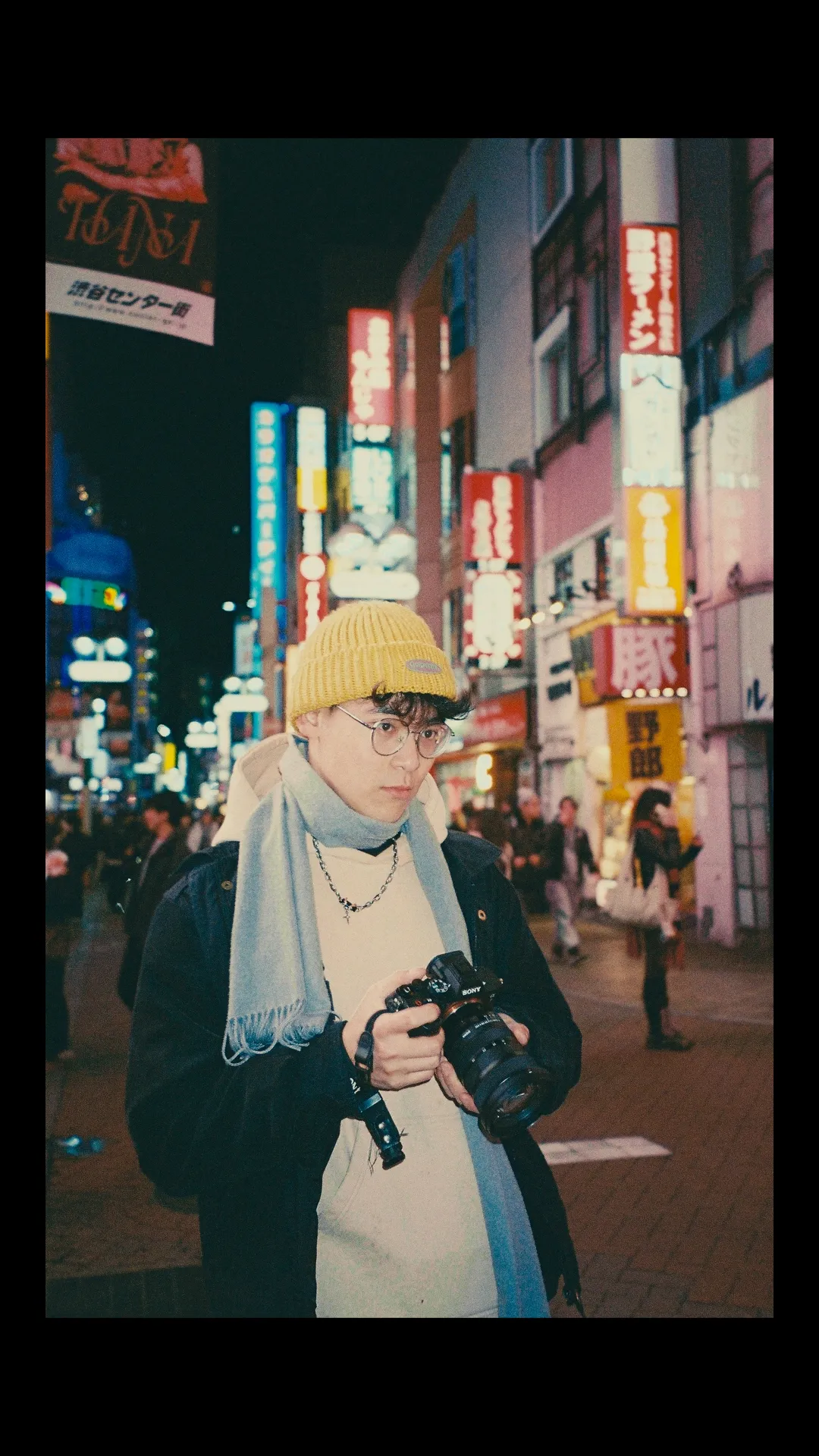 Portrait of the filmmaker on a neon-lit street in Tokyo