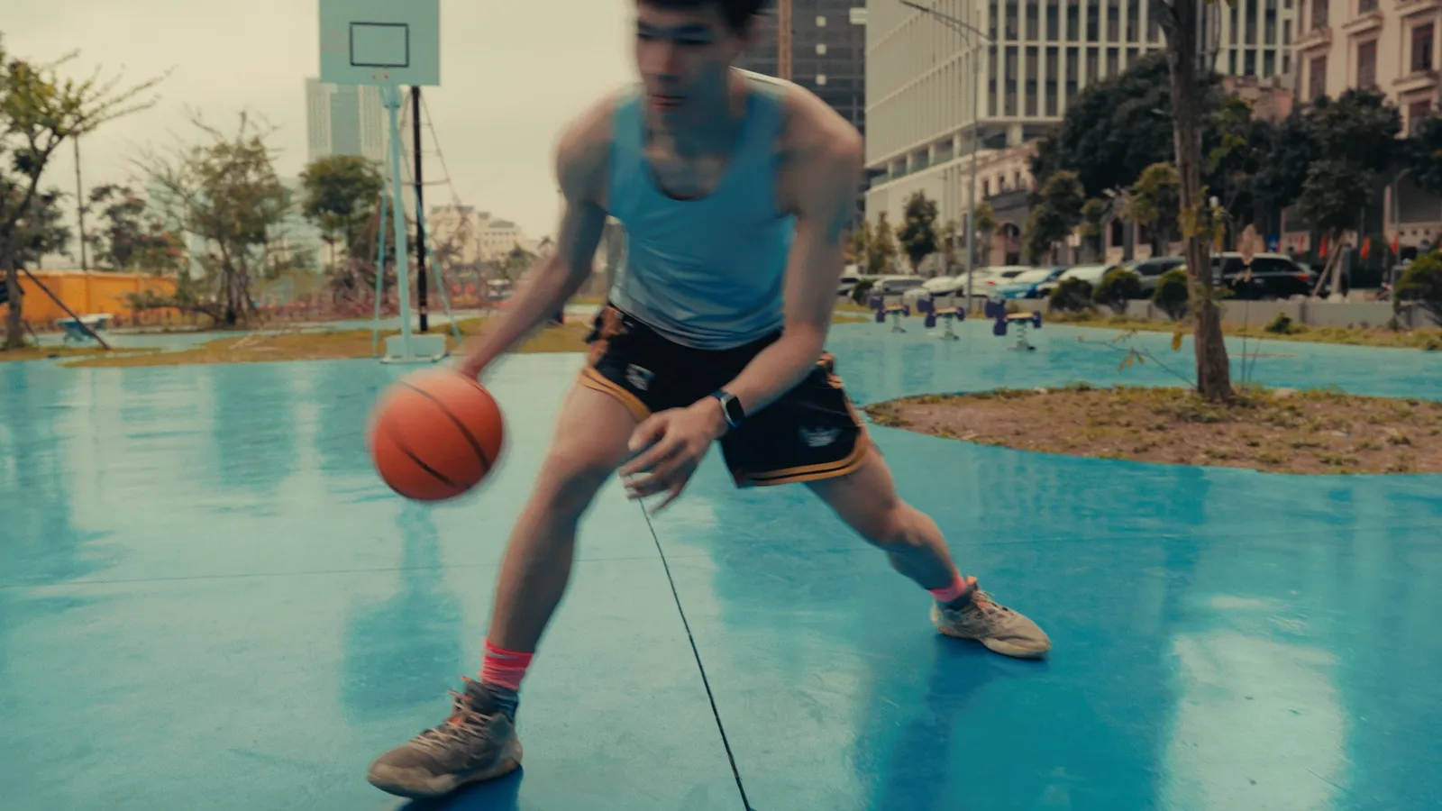 Dribbling low in a tank top and pink socks